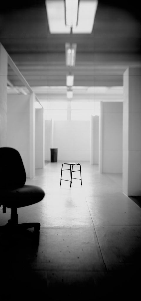 Lizzie King & Craig Tattersall, Studios (2015). Image courtesy of artists. Photograph of swivel chair in foreground and a stool in the centre of the shot in a deserted artist studio.