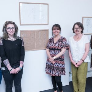 Group of people stood in front of artwork.