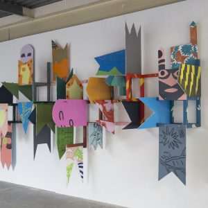 Painted pieces of wood attached to a wall, with some pieces protruding from the wall.