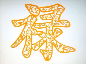A papercut of a Chinese symbol in yellow. On closer inspection of the symbol you can make out company logos.