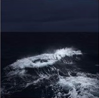 Photograph of waves at night.