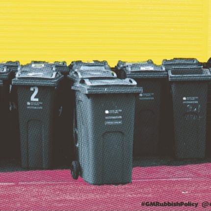 Print of wheelie bins against a yellow background and stood on a pink ground.
