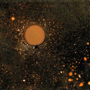 Black background with star like orange specks on it and one larger orange planet like circle.