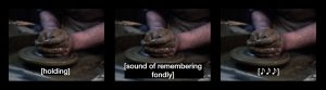 A still from an artists' video. Three identical images are shown side by side. They show a pair of hands sculpting a piece of clay on a potters wheel. Each image has a different text caption written in white text. The first reads 'holding', the second reads 'sound of remembering fondly' the third just has three asterisk * stars