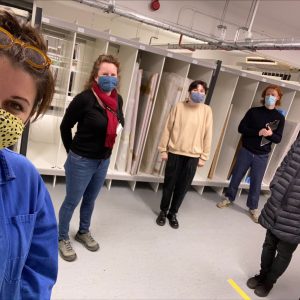 A group photo of five people inside a fine art store room