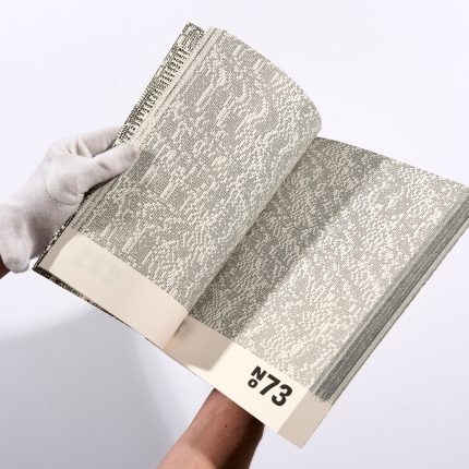 two gloved hands hold open a book, the pages of which are full of numerical code