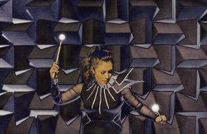 A stylised image of procussionist Jennifer Walinetski, in the angular Conductor costume, in a dramatic pose, holding a drum stick in each hand. Behind her are the dramatic and angular foam walls of the Anecoic Chamber at the University of Salford.