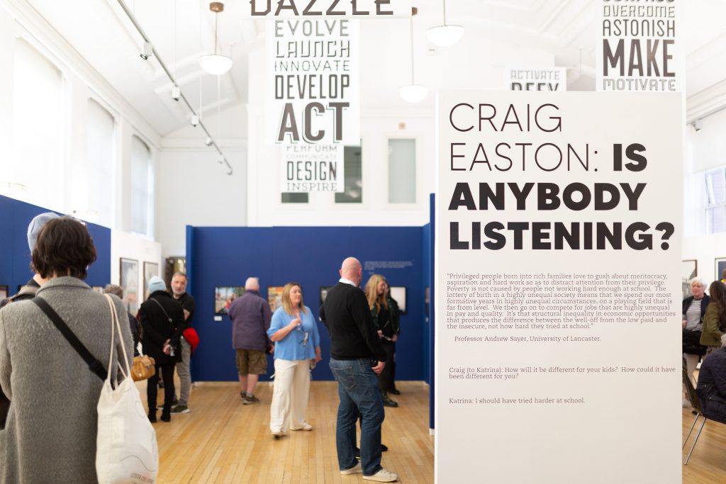 An images of Craig Easton: Is Anybosy Listening? Installed at Blackpool School of Arts, with people viewing the artwork at the exhibition launch. 