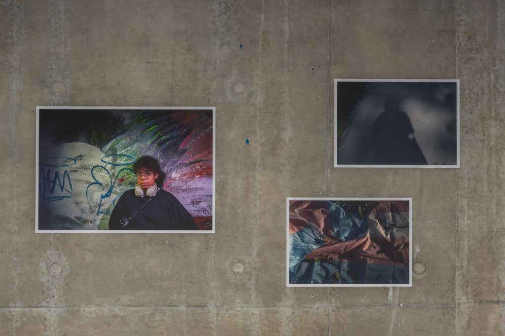 Images created by young people from Salford are presented against a concrete wall.