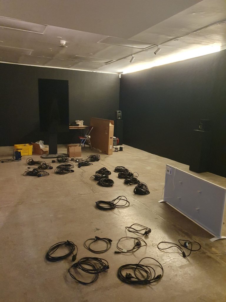 The basement of Castlefield Gallery with a flurry of cables and wires on the floor.