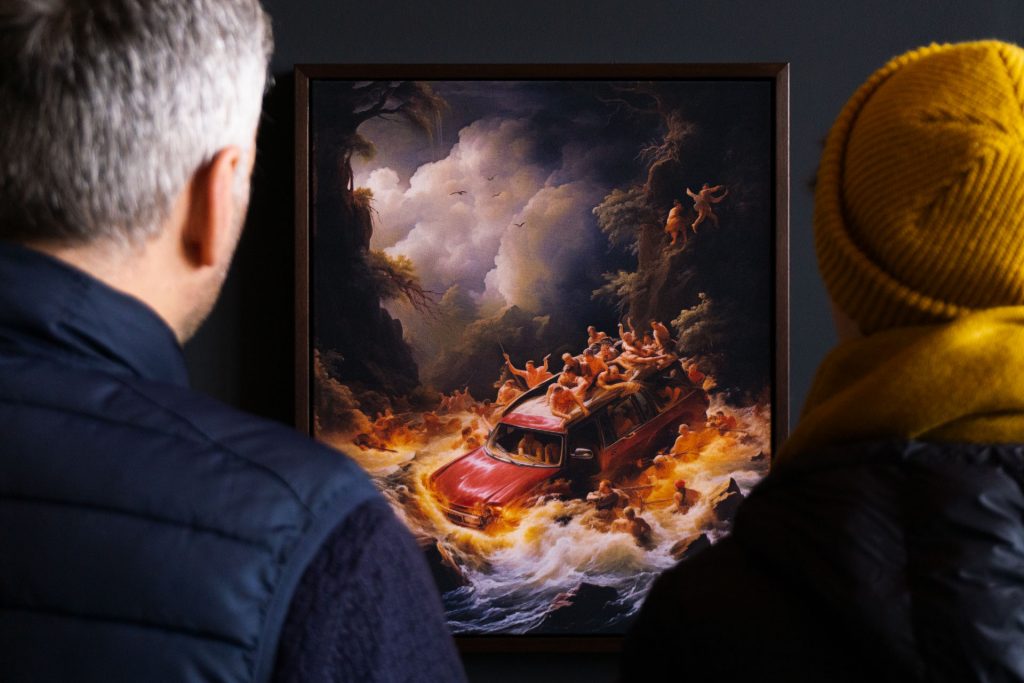 Mishka Henner (left) and Steph Fletcher (right) looking at one of Henner's works (center).