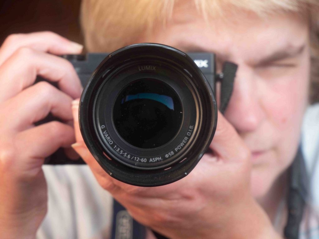 A photograph of artist Fiona Robinson, this image is shot looking directly down the lens barrel as Fiona takes the image - it may be a mirror shot.