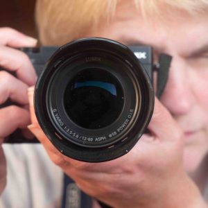A photograph of artist Fiona Robinson, this image is shot looking directly down the lens barrel as Fiona takes the image - it may be a mirror shot.