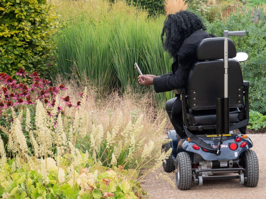 This image shows a community member in an assisted wheelchair participating in a photo workshop set-up by Fiona Robinson.