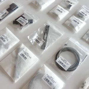 an image showing small metal fixings in bags, used for artworks. Some are in plastic bags, some in paper bags, demonstrating a sustainable switch