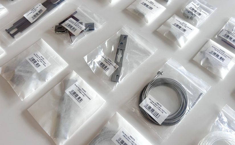 an image showing small metal fixings in bags, used for artworks. Some are in plastic bags, some in paper bags, demonstrating a sustainable switch