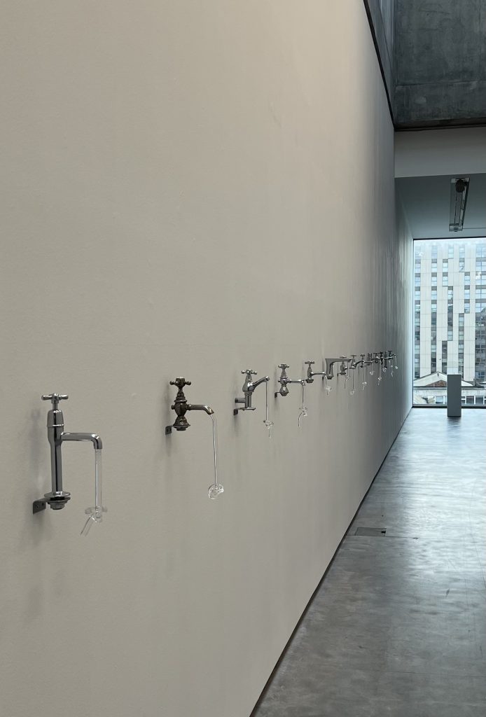 Artwork installation of taps with knotted glass